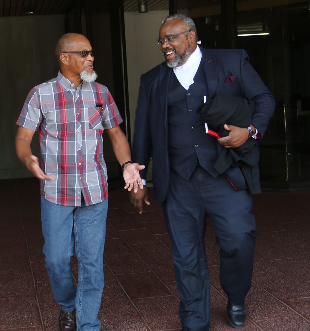 T&T Super League president, Keith Look Loy, left, with his attorney Matthew Gayle leaves Hall of Justice in Port-of-Spain after winning his case against the T&T Football Association (TTFA), yesterday.