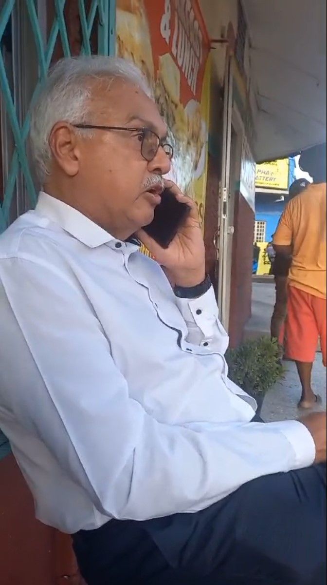 Health Minister Terrence Deyalsingh making a phone call after he was robbed at the Nyahbinghi’s Cultural Centre in St Joseph on Tuesday.