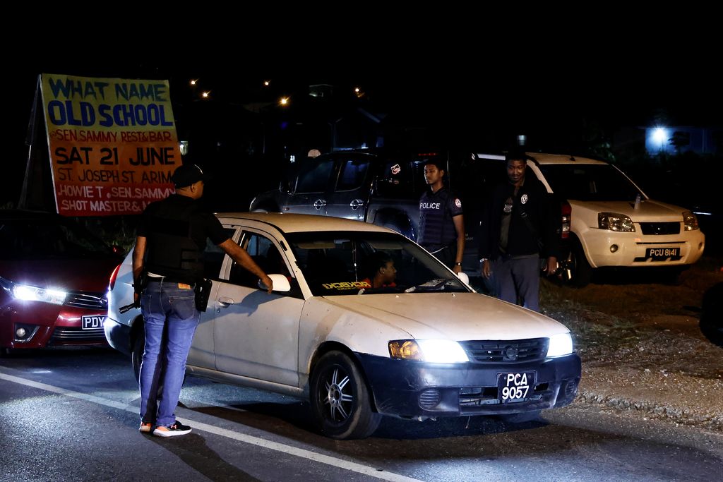 Police officers conduct a roadblock exercise along the Eastern Main Road in Arima, after the announcement of the State of Emergency on Friday.