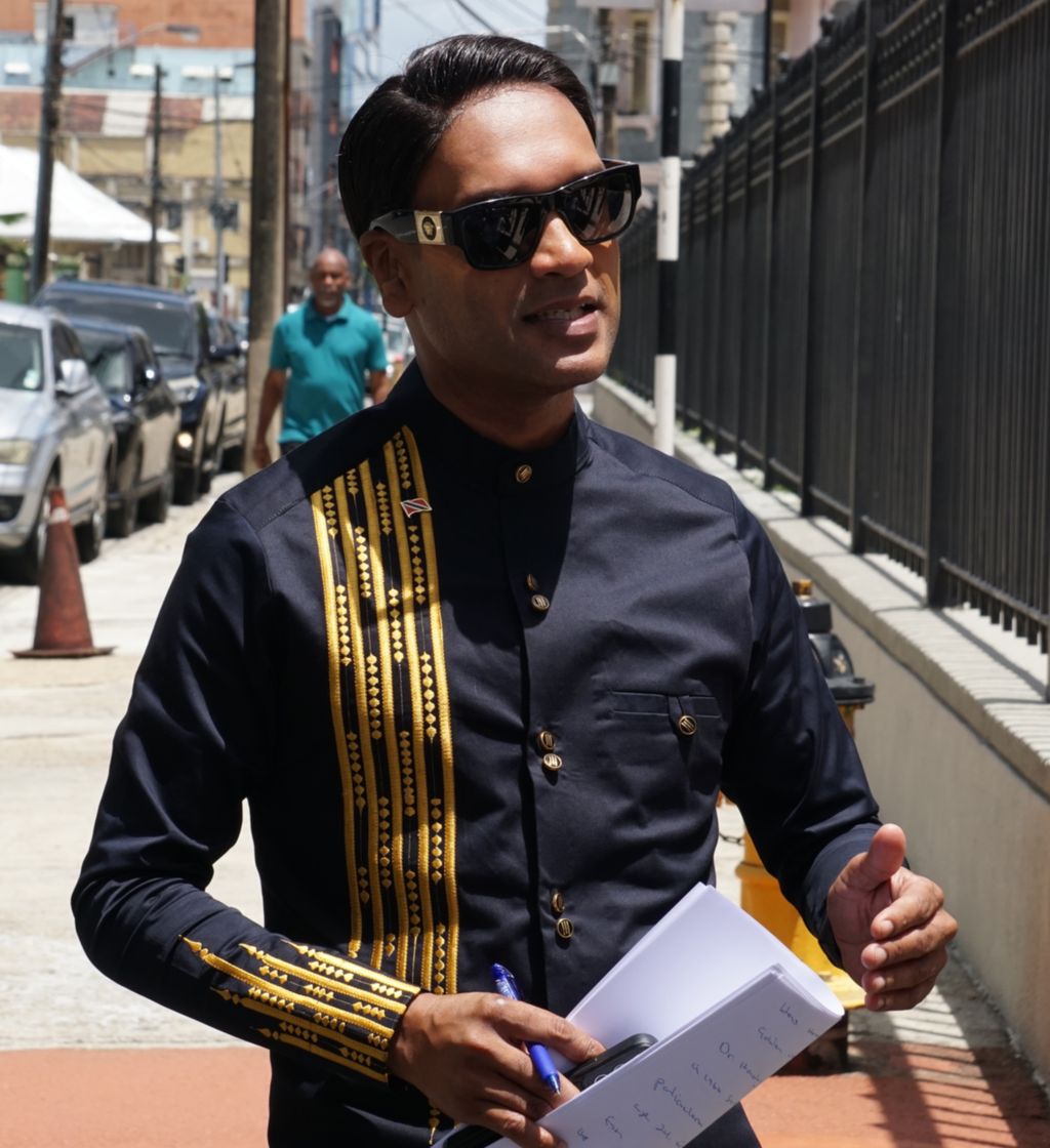 Minister of Public Utilities Barry Padarath speaks to members of the media outside the Red House before attending the sitting of Parliament yesterday.