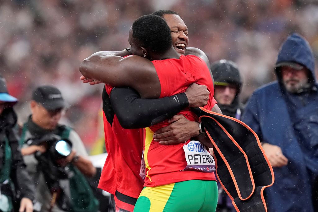 Trinidad and Tobago gold medallist Keshorn Walcott, left, embraces silver medallist, Grenada’s Anderson Peters, after competing in the men’s javelin final at the World Athletics Championships in Tokyo, Japan, yesterday.